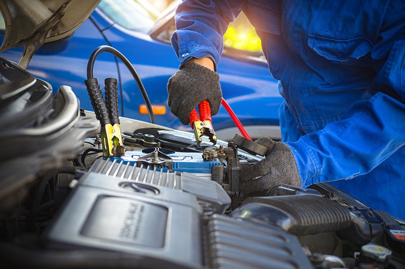 image of a mechanic charging a battery